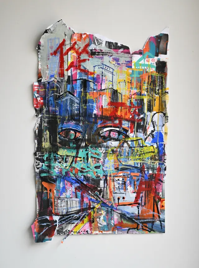 A torn-edge mixed-media artwork combining a face, streets, vehicles, and colorful marks.